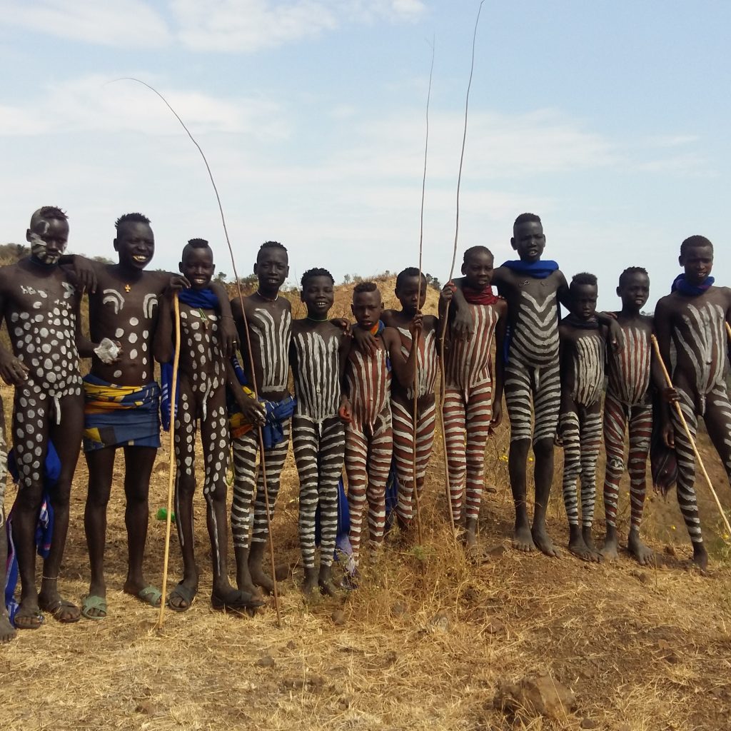 Mursi tribe woman with traditional lip plate in Ethiopia Hamar tribe cultural dance in Southern Ethiopia Scenic landscape of the Omo Valley region Traditional tribal market in Jinka Ethiopia Karo tribe body painting near the Omo River Travelers enjoying the 7-Day Omo Valley Tour in Ethiopia